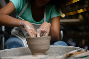 African woman make earth ware at workshop.
