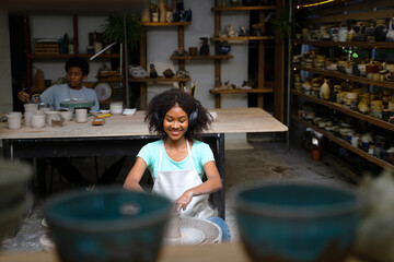 African woman make earth ware at workshop.