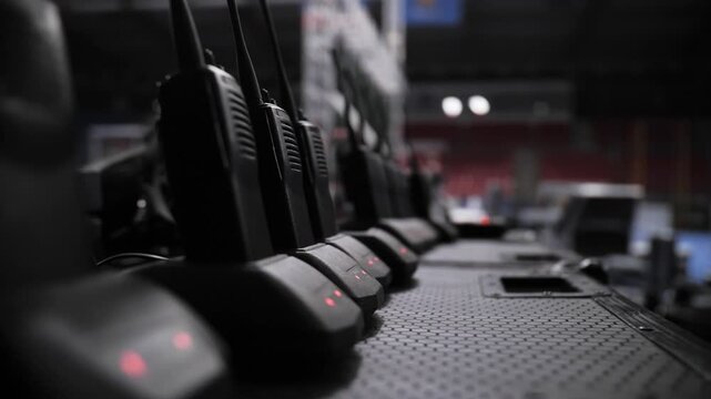 Row of walkie talkies charging at event backstage