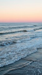 Gentle rolling ocean waves under pastel pink and blue sky at peaceful sunrise
