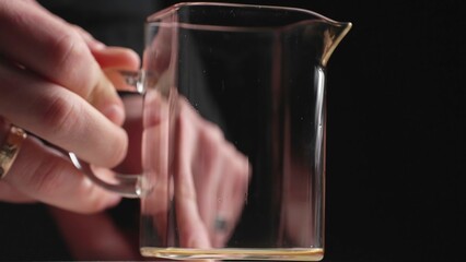 A Hand Holding a Transparent Glass Mug That Contains Liquid Drink Creatively Displayed. Media
