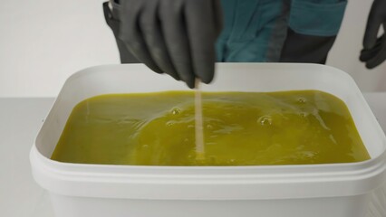 A person handles vibrant green liquid in various ways. Creative