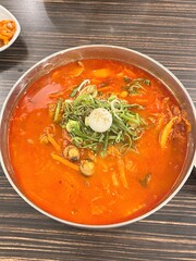 A steaming bowl of jjampong, the spicy Korean-Chinese noodle soup loaded with seafood, vegetables, and rich, flavorful broth. A hearty and satisfying comfort dish.