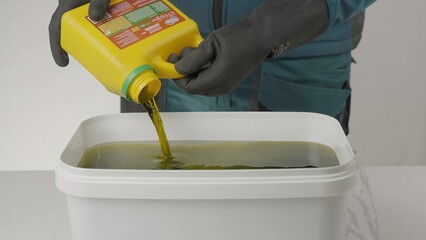 A video shows a person pouring yellow liquids into a white bucket. Creative