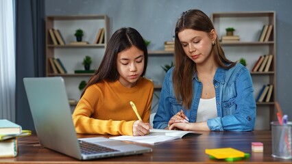 Woman and Teen Girl Studying Together at Home Table