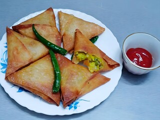 Relish these golden, crispy vegetable samosas filled with spicy potato mixture, served with fried...