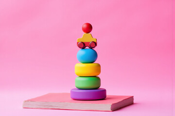 stack of colorful wooden toys sitting on top of a stack of books