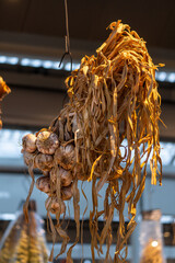 Close-up of braids of dried garlic bulbs hanging from the ceiling at a market.