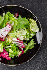 Salad mixed leaves iceberg, batavia, lettuce, radicchio, romano, frisee appetizer vegetables dish organic fresh tasty gourmet food background on the table copy space keto paleo diet vegetarian vegan