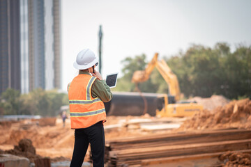 Engineer worker operations construction plans large black drainage pipe installing underground...