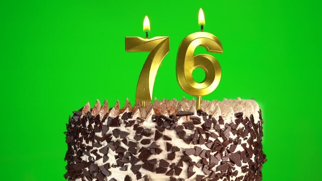 Burning candles number 76 on birthday cake against chroma key background. Seventy-sixth birthday. Birthday celebration