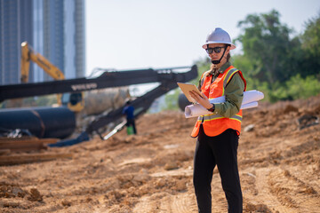 Engineer worker operations construction plans large black drainage pipe installing underground...