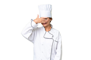 Middle-aged chef woman over isolated background covering eyes by hands and smiling