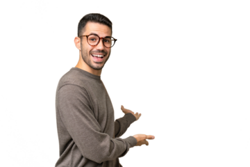 Young handsome caucasian man over isolated background extending hands to the side for inviting to come