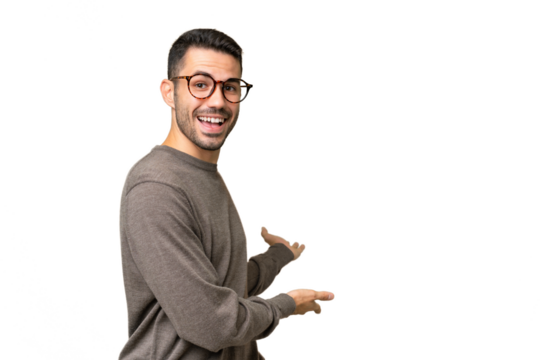 Young handsome caucasian man over isolated background extending hands to the side for inviting to come