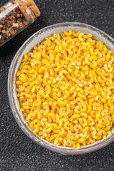 Pasta raw coquillette macaroni dish organic product fresh tasty gourmet food background on the table rustic food top view copy space