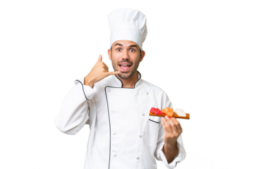 Young caucasian chef holding a sushi over isolated background making phone gesture. Call me back sign