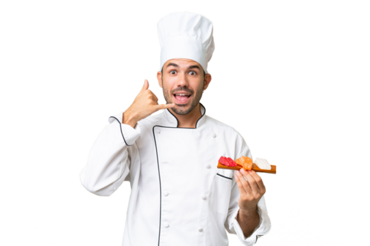 Young caucasian chef holding a sushi over isolated background making phone gesture. Call me back sign