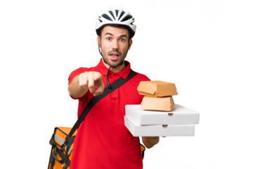 Young handsome caucasian man with thermal backpack and holding takeaway food over isolated background surprised and pointing front