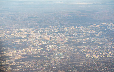 Plane window view of snow Polish fields and villages, Krakow suburbs, aircraft fly landscape