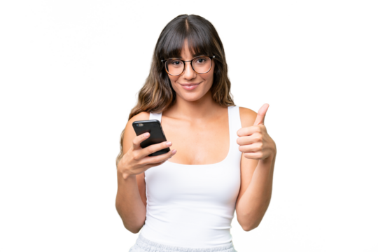 Young caucasian woman over isolated background using mobile phone while doing thumbs up
