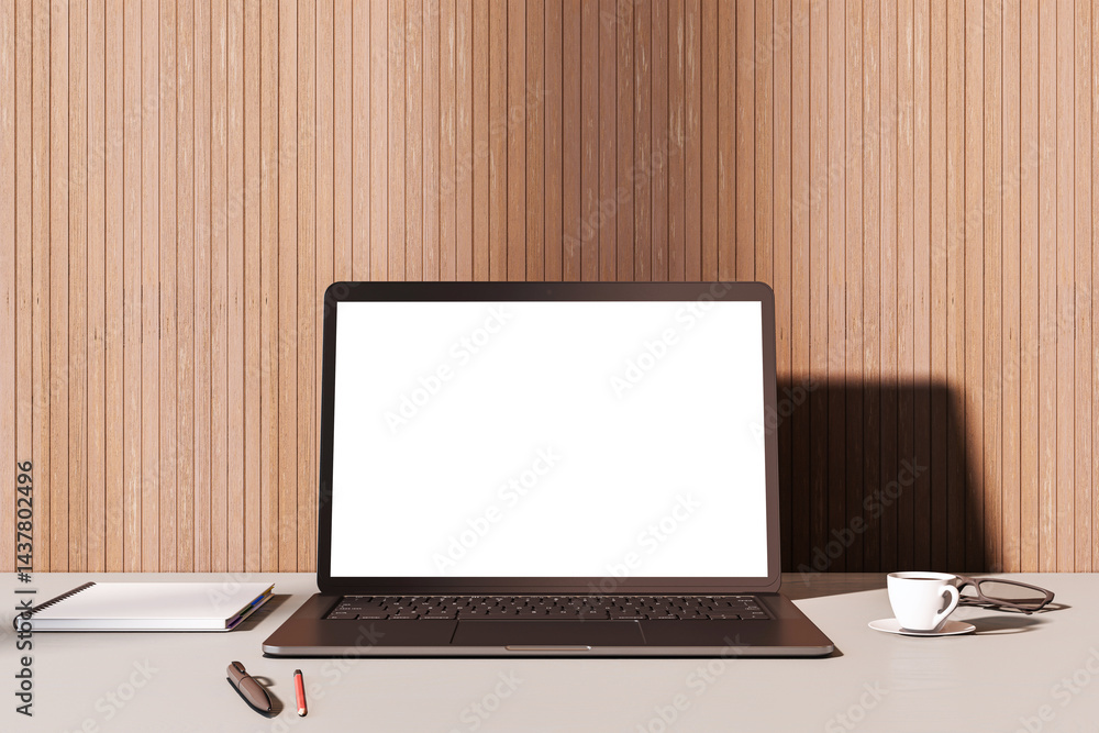 Poster blank laptop screen on desk with coffee cup and notebook in stylish wooden interior room setup for w