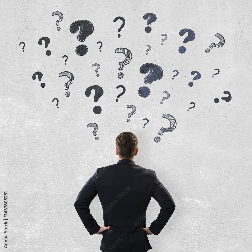 Poster businessman standing with hands on hips facing a wall of scattered question marks, symbolizing confu