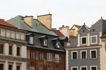 Traditional European architecture with vibrant facades, red clay roof tiles, dormer windows, and ornate exterior wall decorations in a picturesque old town setting