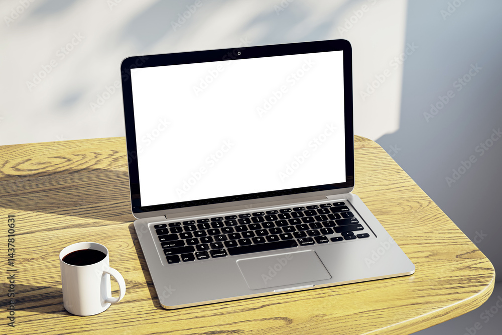 Poster blank screen laptop mockup on wooden desk with coffee mug in home setting for presentation or advert