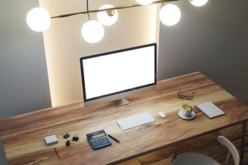 Modern workspace mockup with blank computer screen on wooden desk in stylish office room under bright interior lighting setup from top view. 3D Rendering