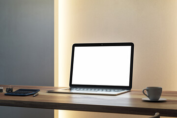 Blank laptop screen on wooden desk with coffee cup and calculator in modern office interior mockup layout for clean presentation template. 3D Rendering
