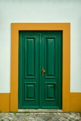 old green door in white wall orange background paint