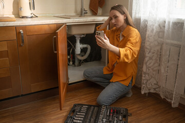 In a cozy kitchen, a woman seeks help from a repair service as she addresses a malfunctioning sink...