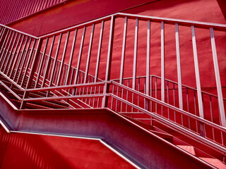 A set of stairs ascending a large red wall