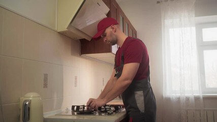 Skilled technician installing gas stove, ensuring safety and functionality in residential kitchen, showcasing expertise in home appliance installation