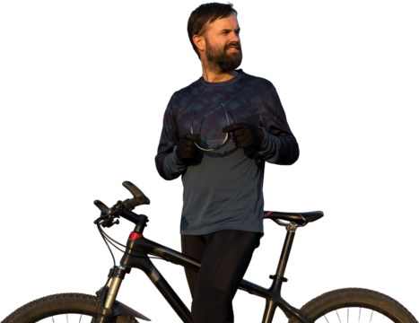 Cyclist in shorts and jersey on a modern carbon hardtail bike with an air suspension fork standing on a cliff against the background of fresh green spring forest