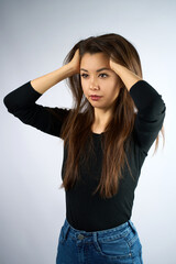 Portrait of Beautiful Smiling Young Woman. A gorgeous woman with long brown hair against a plain light grey backdrop