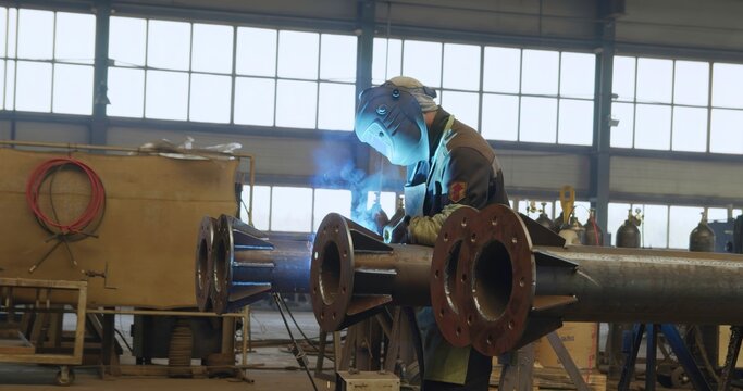 An Industrial Worker Wearing Protective Gear in a Workshop Environment While Working. Media