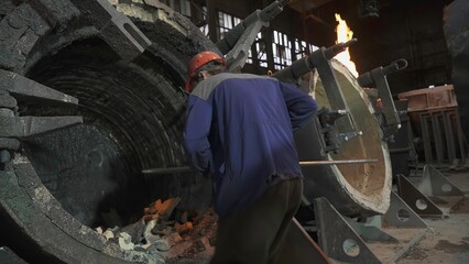 A worker is currently present inside an industrial facility where they are handling equipment. Stock Clip