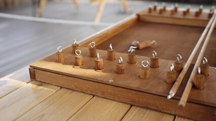 A beautifully crafted wooden game is resting on a sturdy wooden table. Creative