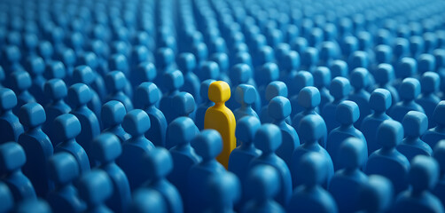 Obraz premium A yellow person standing out from the crowd of blue people.