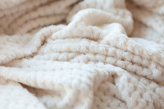 Cozy Comfort: A close-up of a soft, textured blanket, inviting warmth and relaxation, with its gentle folds and plush feel.