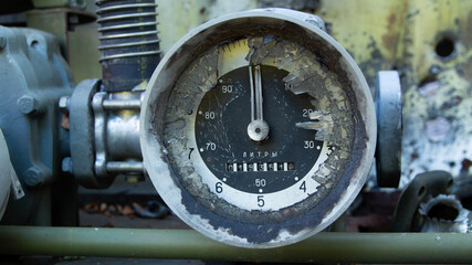 Worn and damaged analog gauge showing fuel volume in liters, from a tank or large container.