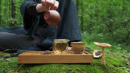 Enjoy a serene tea ceremony in a tranquil forest, surrounded by nature for relaxation. Media