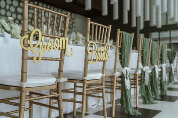 Chairs decorated with beautiful flowers are placed for the bride and groom.