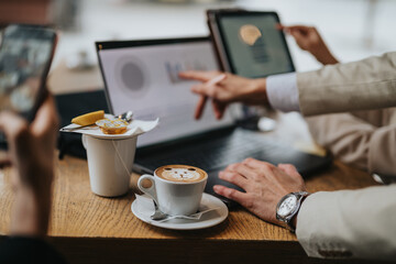 People working together on a project at a cozy cafe, featuring laptops, teamwork, and an artistic cappuccino with bear inspired latte art, creating a creative atmosphere for business discussions.