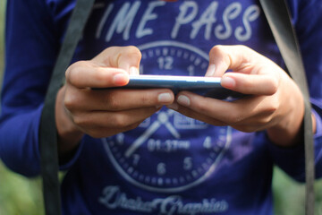 A man playing a game on his mobile with both hands