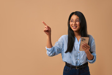 A Confident Young Woman Posing in a Casual Outfit with Style Against a Beige Background
