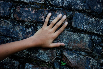A man put his hand and finger on the dirty wall
