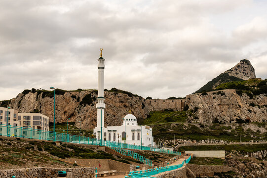 Ibrahim-al-Ibrahim Mosque with Rock of Gibraltar in Background. Scenic view of Mosque at Europa Point in Gibraltar, with dramatic cliffs and the iconic Rock of Gibraltar rising in the background. - Powered by Adobe